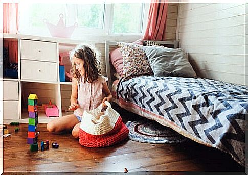 Girl picking up toys by applying an operant conditioning technique