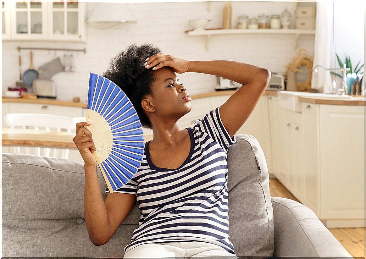 Woman with heat fanning herself