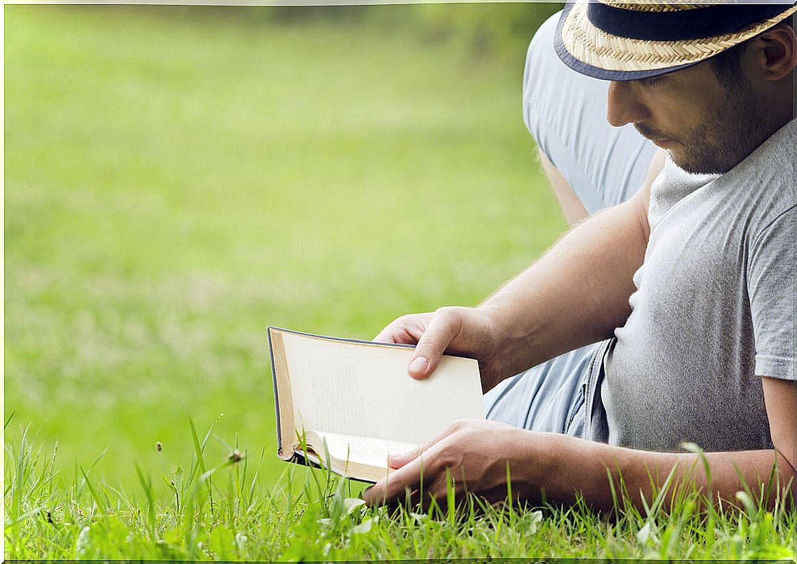 Man reading a book on the grass