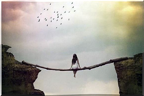 woman sitting on a log and suspended in an abyss