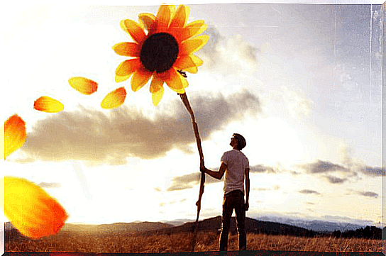 man holding sunflower symbolizing the Pollyanna principle