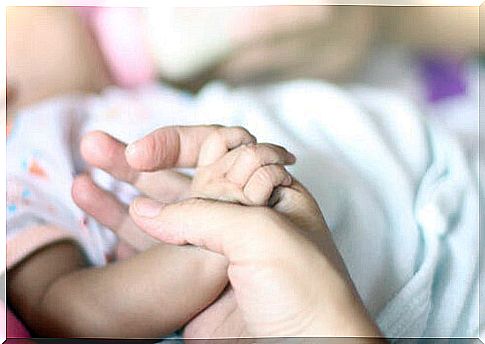 Mother holding baby's hand