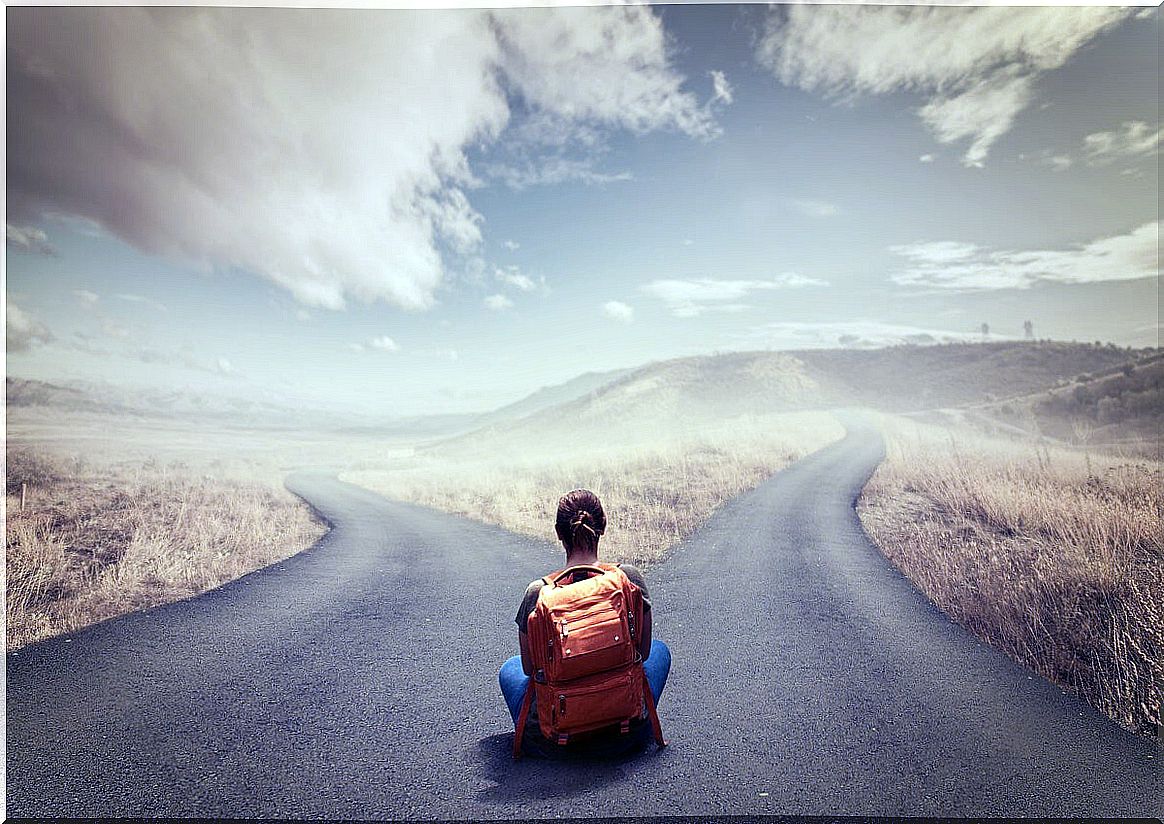 Woman sitting in front of two roads