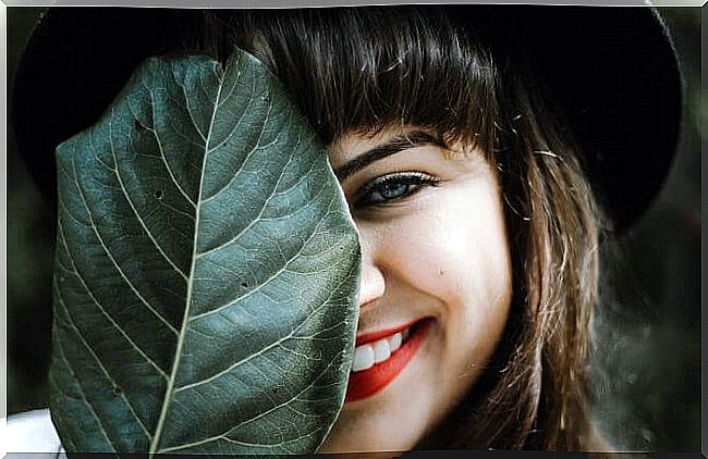 girl with a leaf on her face covering her Duchenne smile