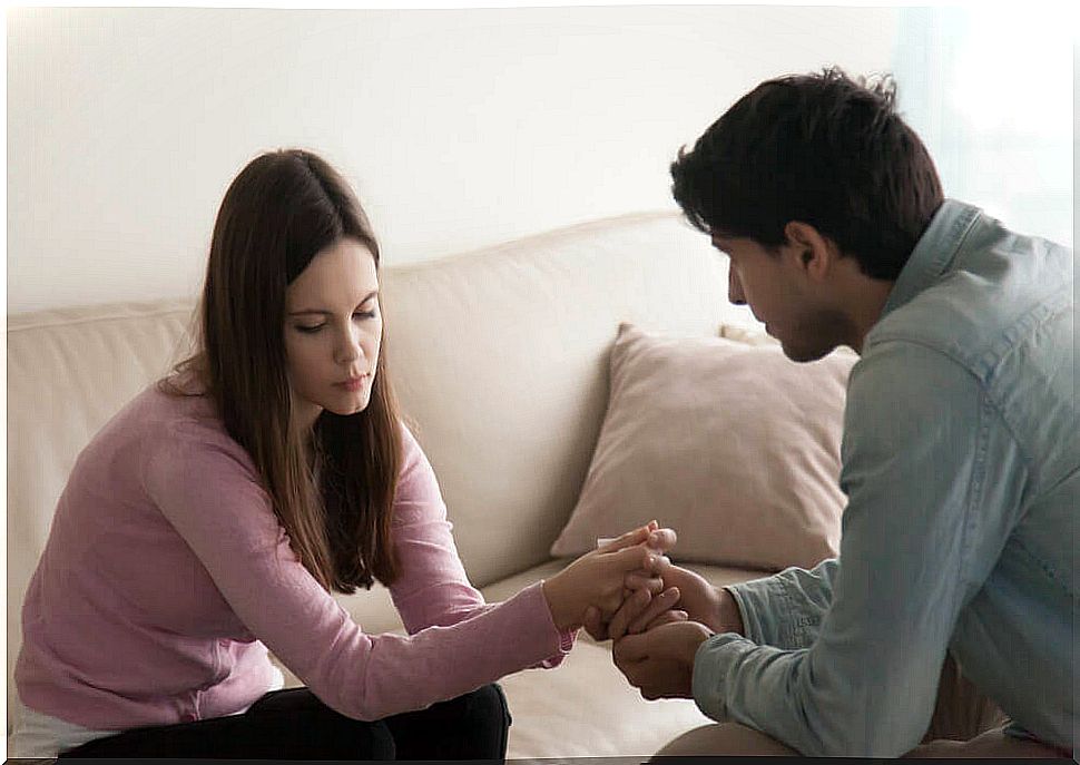 Boy holding the hand of a girl disappointed by broken love promises