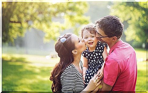 Parents hugging their daughter